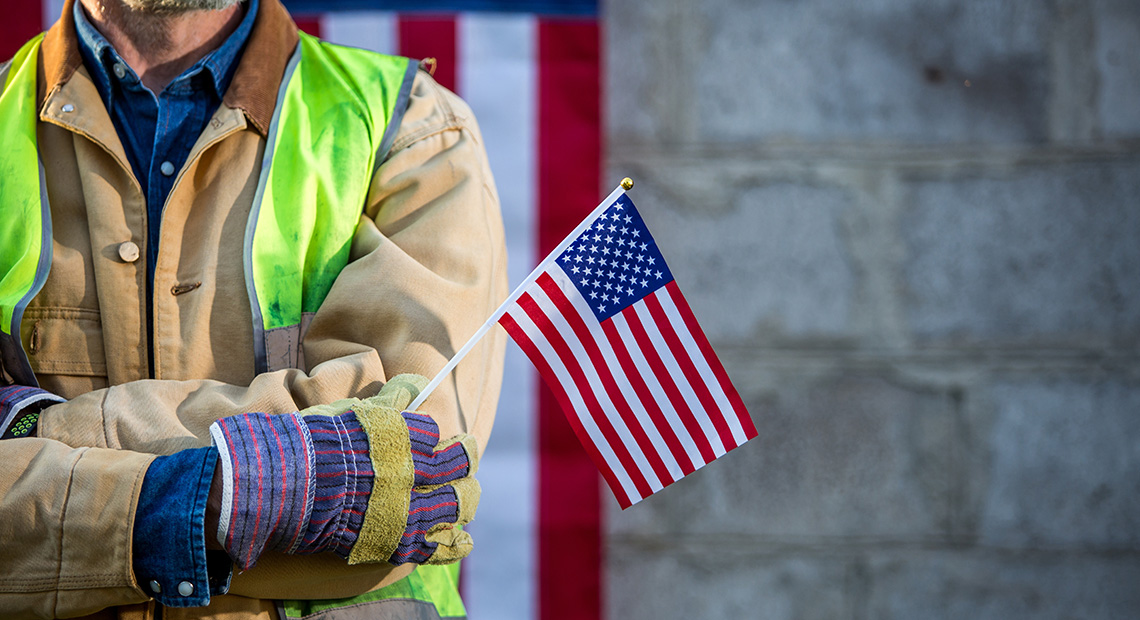 Image of a union worker holding a small US flag.